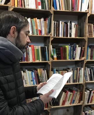 Imagen de Tomás ante un texto en una biblioteca