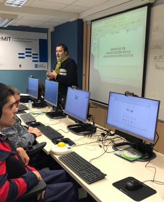 Jorge con compañeros en una clase con ordenadores  