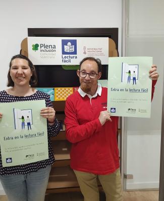 Paula y Mauri mostrando un cartel en el que se lee 'Entra en la lectura fácil'