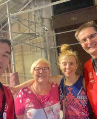 Foto de Eduardo con el chaleco de voluntario de Fundación ONCE y Wizink Center junto a dos mujeres y otro voluntario que lleva un chaleco igual al suyo